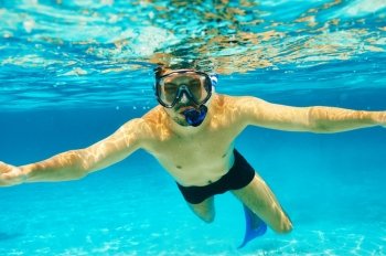 Man with mask snorkeling in clear water 
