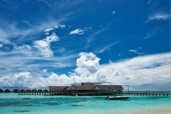 Beautiful island beach with motor boat at Maldives