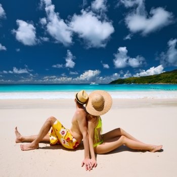 Couple sitting on a tropical beach at Seychelles