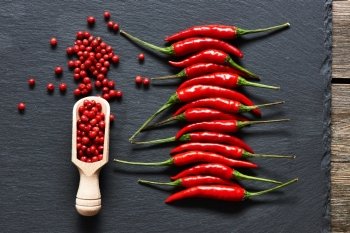 Red hot chili peppers and rose pepper on slate background 