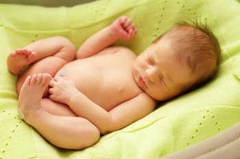 One week old newborn baby in cocoon. Focus on feet. 