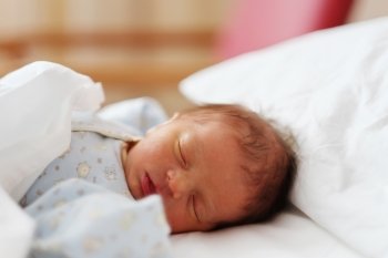 Two days old newborn baby in bed 