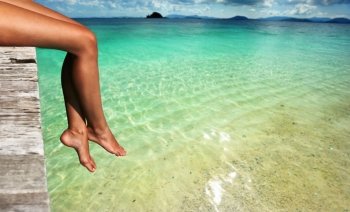 Woman’s legs at beach jetty