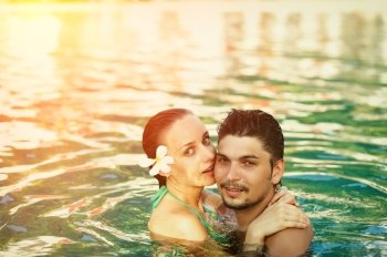 Couple in tropical swimming pool