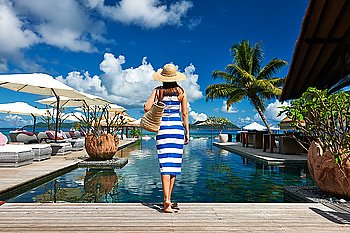 Woman in sailor striped dress near poolside jetty at Seychelles
