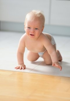 Baby boy crawling on floor