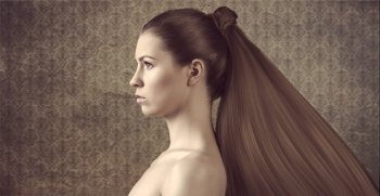 pretty young girl with naked shoulder and long hair tail in a grunge background
