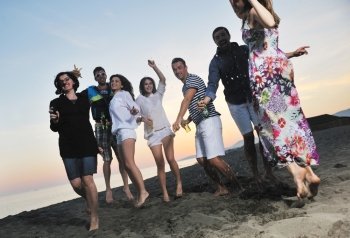 Group of young people enjoy summer  party at the beach on beautiful sunset