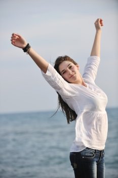 happy young woman relax on beautiful  beach at fresh summer morning and enjoy first ray of sun