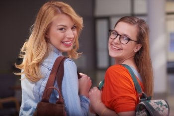 friends together at school, two student girls with backpack and tablet on university