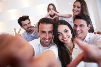 group of friends taking selfie photo with tablet at modern home indoors