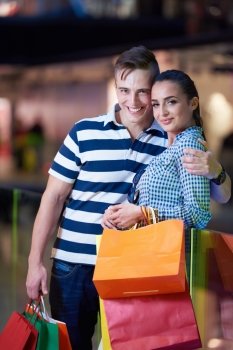 young couple with shipping bags in modern mall
