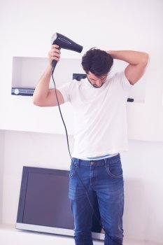 young handsome nude man at home using  hair  hairdryer