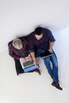startup business and new mobile technology concept with  young couple in modern bright office interior working on laptop and tablet computer on new creative project and brainstorming, aerial top view