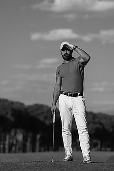 handsome middle eastern golf player portrait at course at sunny day wearing red  shirt