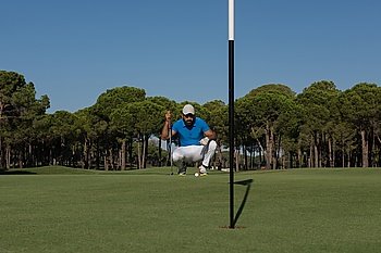 golf player aiming shot with club on course at beautiful sunny day
