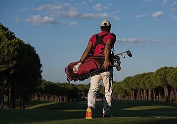 handsome middle eastern golfer  carrying  golf bag  and walking at course to next hole