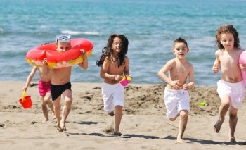 happy child group have fun on beach while playing with toys  running jumping
