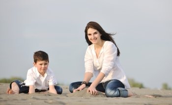 happy young mother  and son relaxing and play ind sand games on beach at summer season