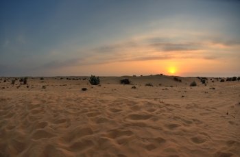 sunset with blue sky and clouds over sand dunes in sahara desert