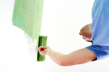 handsome young man paint in blue and green color  white wall of new home