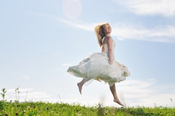 happy young beautiful bride after wedding ceremony event have fun outdoor on meadow at sunset