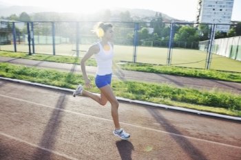 beautiful young woman exercise jogging and runing on athletic track on stadium at sunrise 