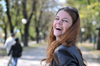 Happy young woman smiling outdoors in park