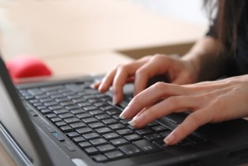 woman hands typing on laptop keyboard