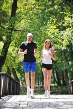 happy young younpe jogging and runing outdoor in nature at sunny day