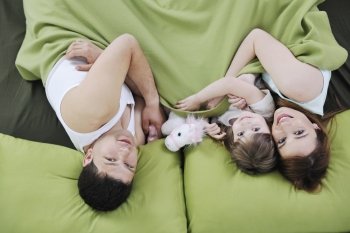 happy young family relaxing in bed 