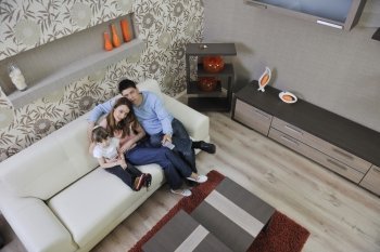 happy youg family relaxing in modern livingroom at home