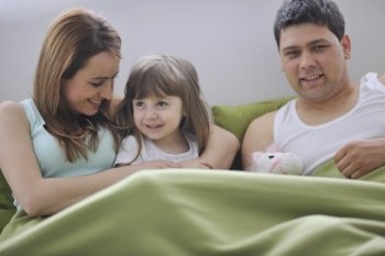 happy young family at home relaxing in bed 