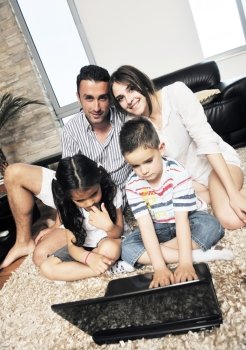 happy young family have fun and working on laptop at modern  home livingroom indoor