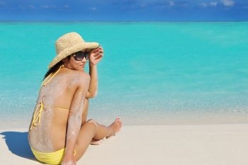 happy young pretty asian woman resting on sand at tropical beach
