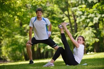 young health couple doing stretching exercise relaxing and warm up after jogging and running in park