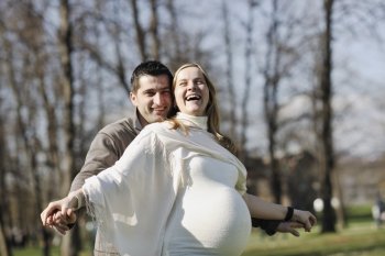 happy young married family couple outdoor in nature have fun and waiting baby and representing young family growth and pregnancy concept