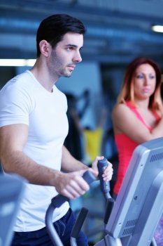 Handsome man running on the treadmill in modern gym