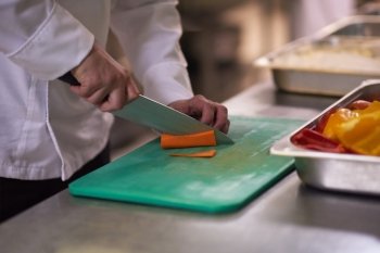 chef in hotel kitchen  slice  vegetables with knife and prepare food