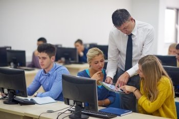 group of students with teacher in computer lab classrom learrning lessons,  get help and support