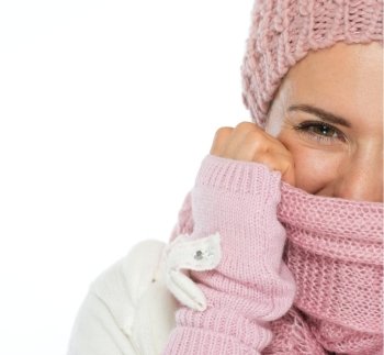Closeup on woman in knit winter clothing closing face with scarf