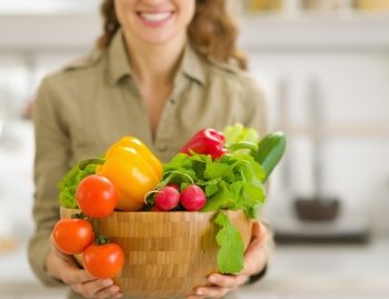 Closeup on plate of fresh vegetables in hand of young housewife