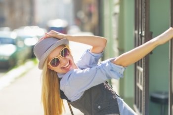 Portrait of smiling hipster girl on city street