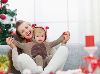 Smiling young mother and baby having fun time on Christmas