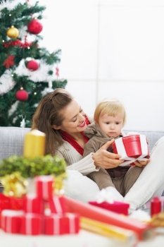 Happy mother showing baby christmas present box