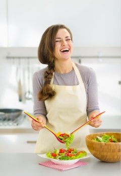 Smiling young woman serving fresh salad on plate