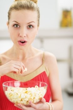 Portrait of young woman eating popcorn