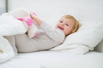 Happy baby playing in bed