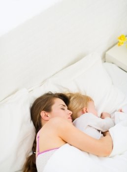 Mother sleeping with baby in bed