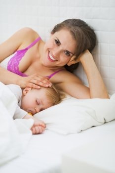 Portrait of happy mother and sleeping baby